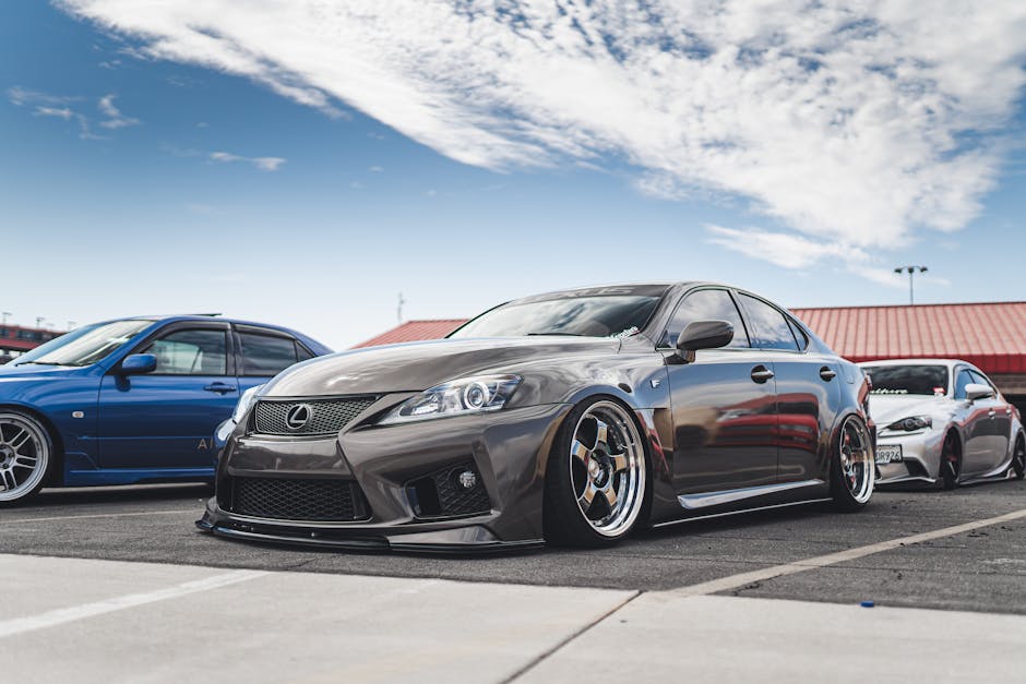 A lineup of sleek, modified sports cars parked outdoors under a blue sky.