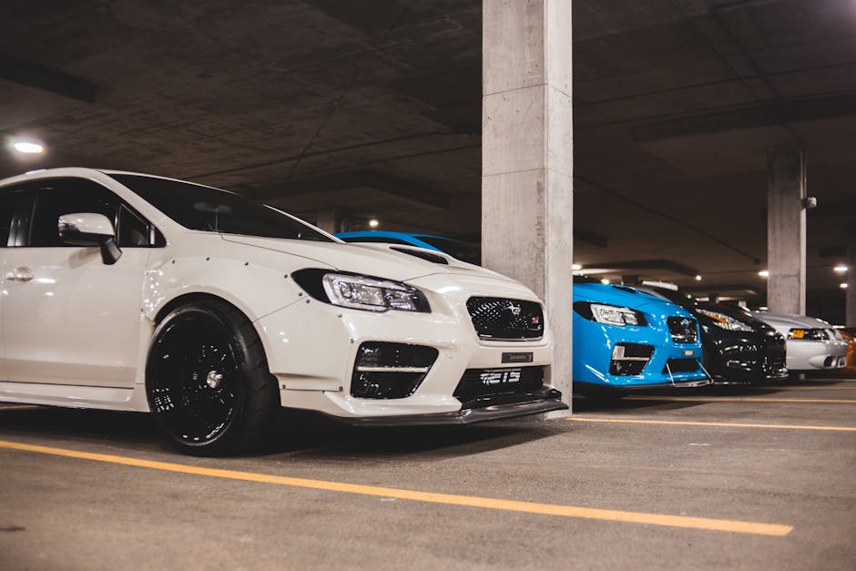 Sleek modern cars lined up in an underground parking garage.